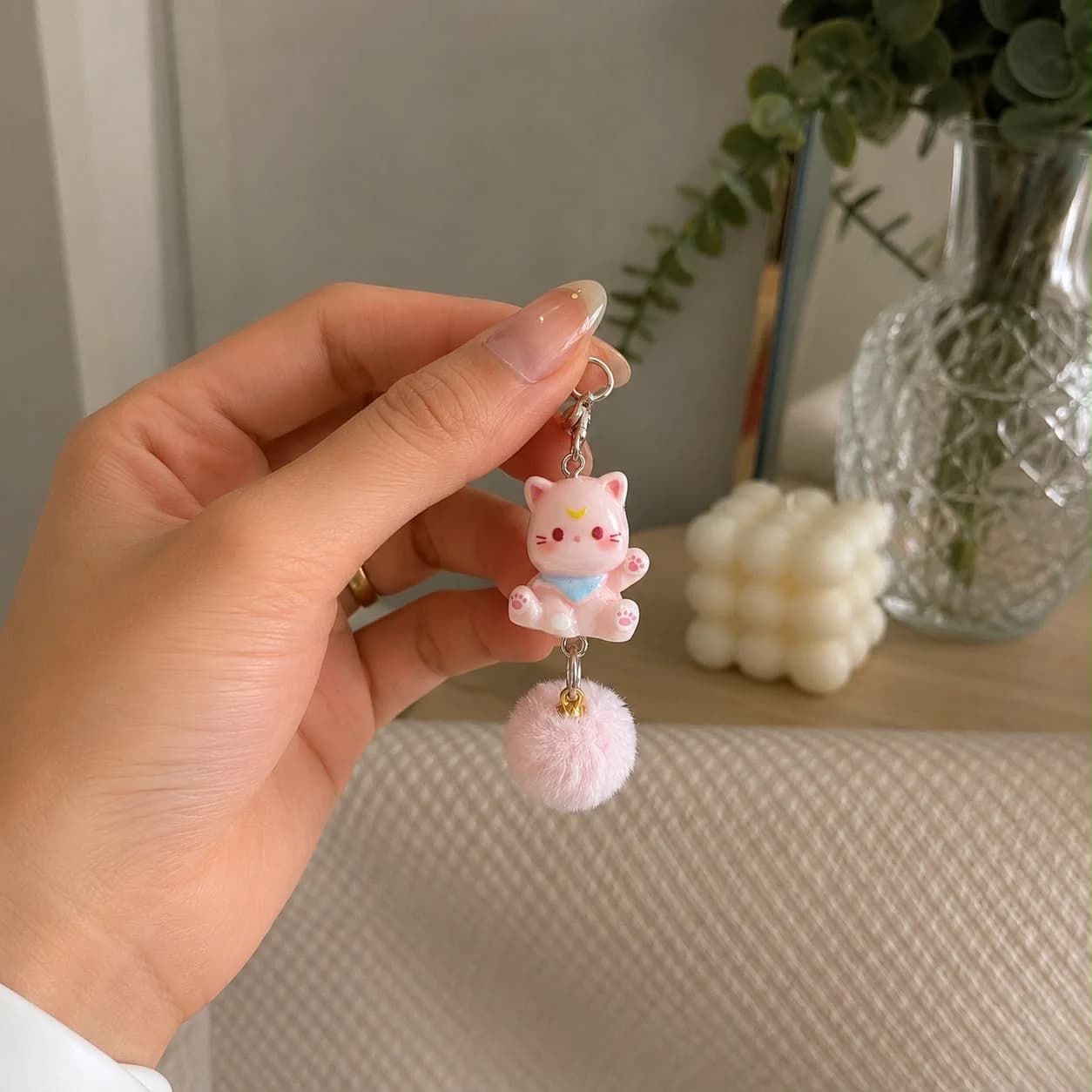 Chaveiro Luna Rosa segurado na mão, pompom rosa em destaque